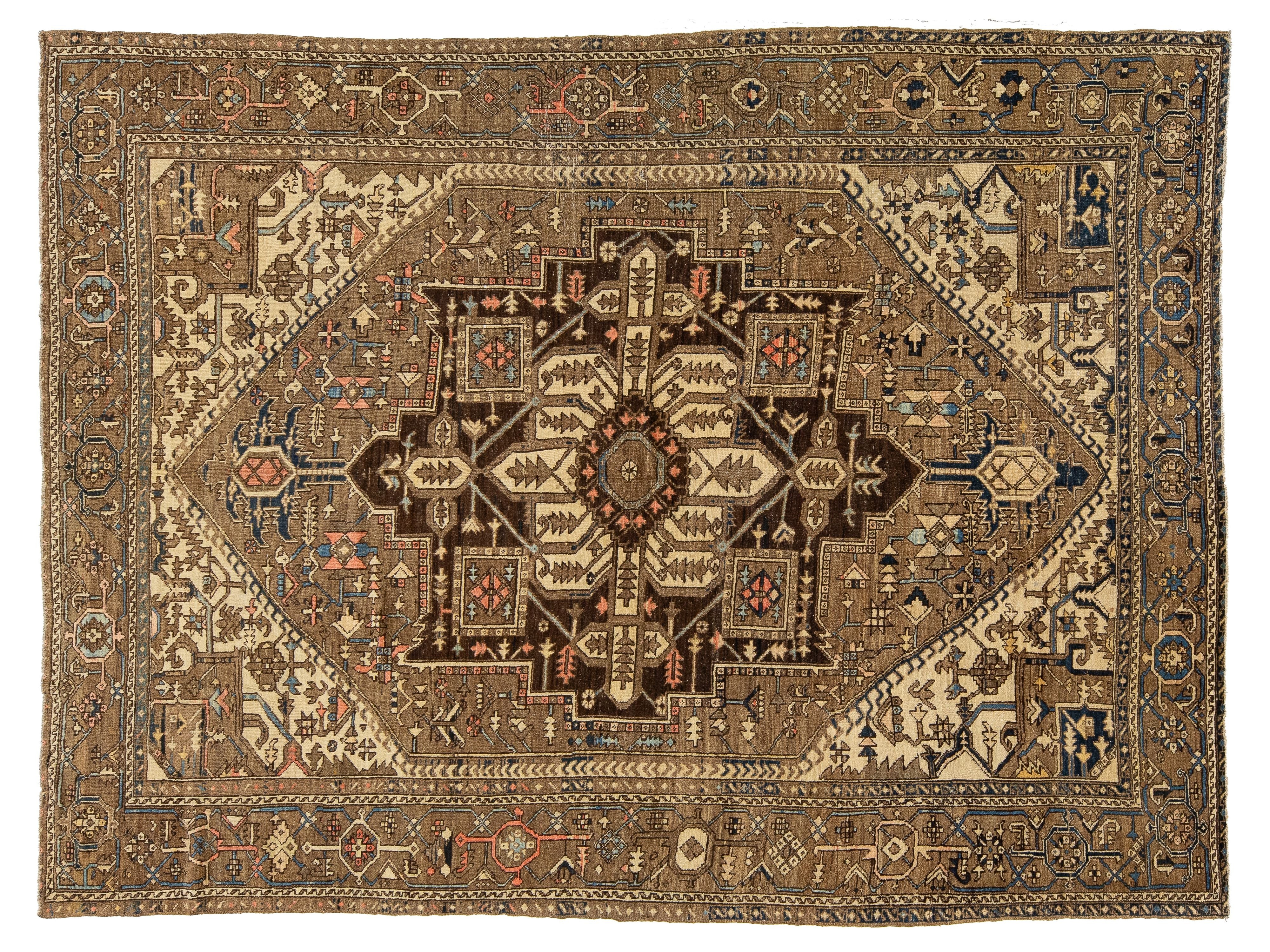 An antique Persian-style wool rug with a central medallion, featuring a warm brown, beige, and navy blue color palette with intricate geometric and floral patterns.