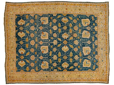A rectangular traditional oriental rug with a deep teal blue field, decorated with a repeating cream and gold floral pattern, surrounded by a wide cream border with intricate gold and red details.