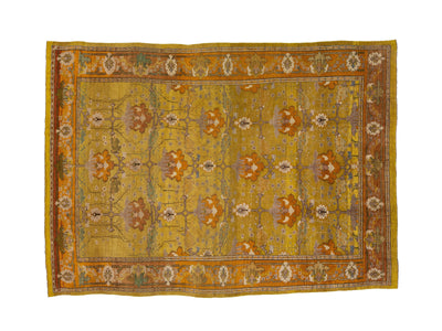 A square vintage arts and crafts style area rug with a mustard yellow field, featuring a central floral medallion pattern in rust orange, beige, and muted green, surrounded by a decorative border.