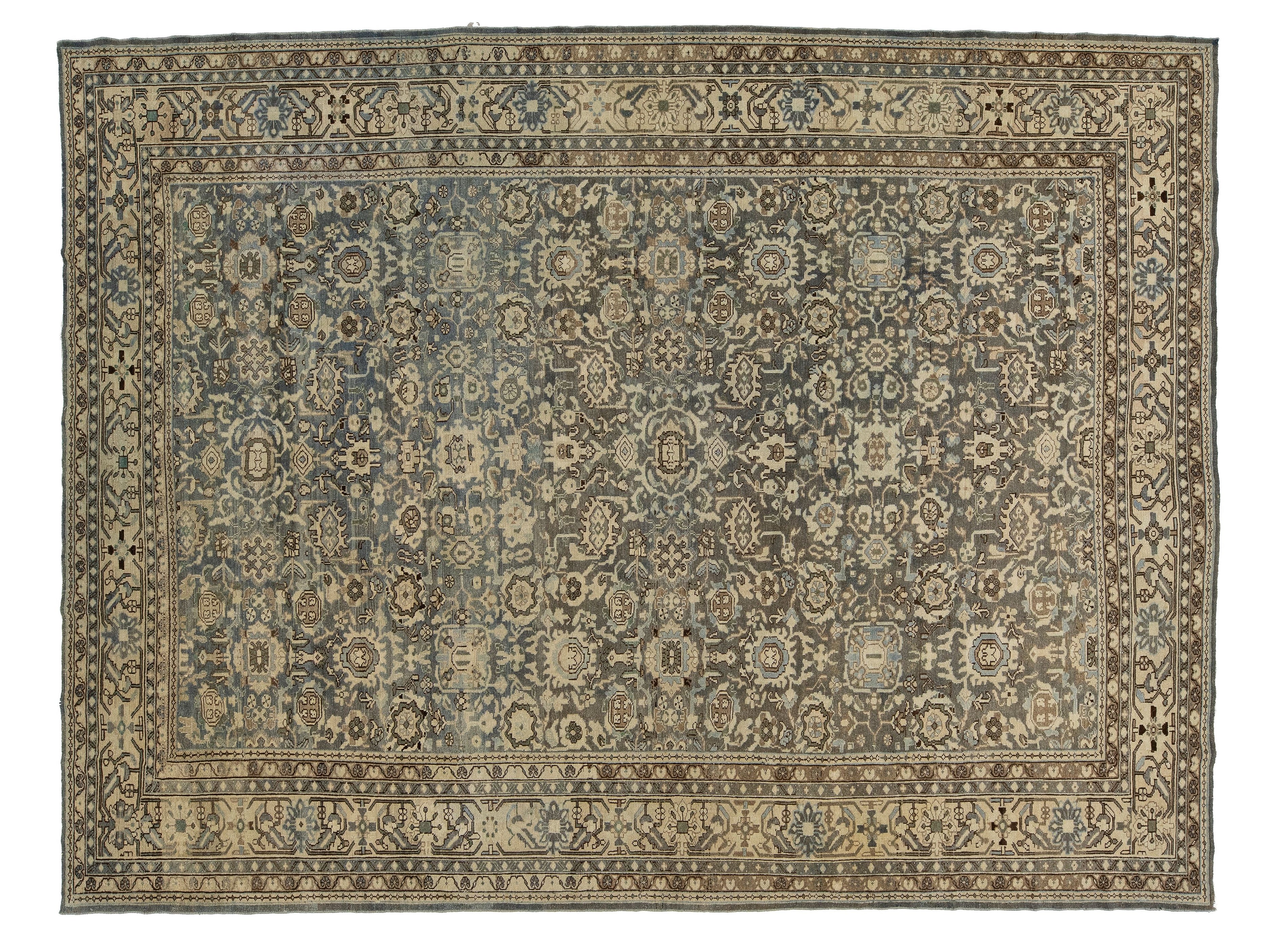 An antique malayer-style oriental rug with a complex floral and geometric pattern in muted blue, beige, and brown tones, shown flat against a white background.