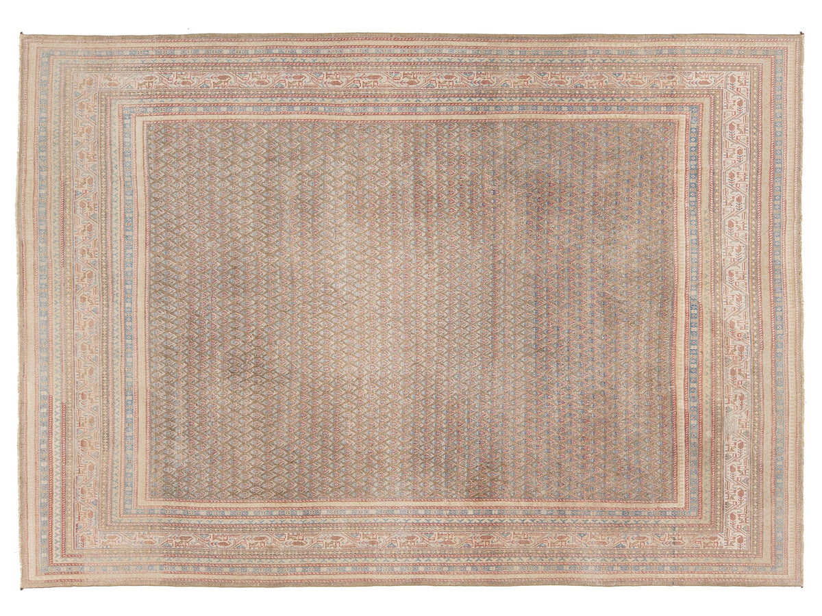 A rectangular area rug with a distressed, antique Tabriz pattern in muted beige, brown, and soft blue tones, featuring a wide central field and detailed multi-layered borders.