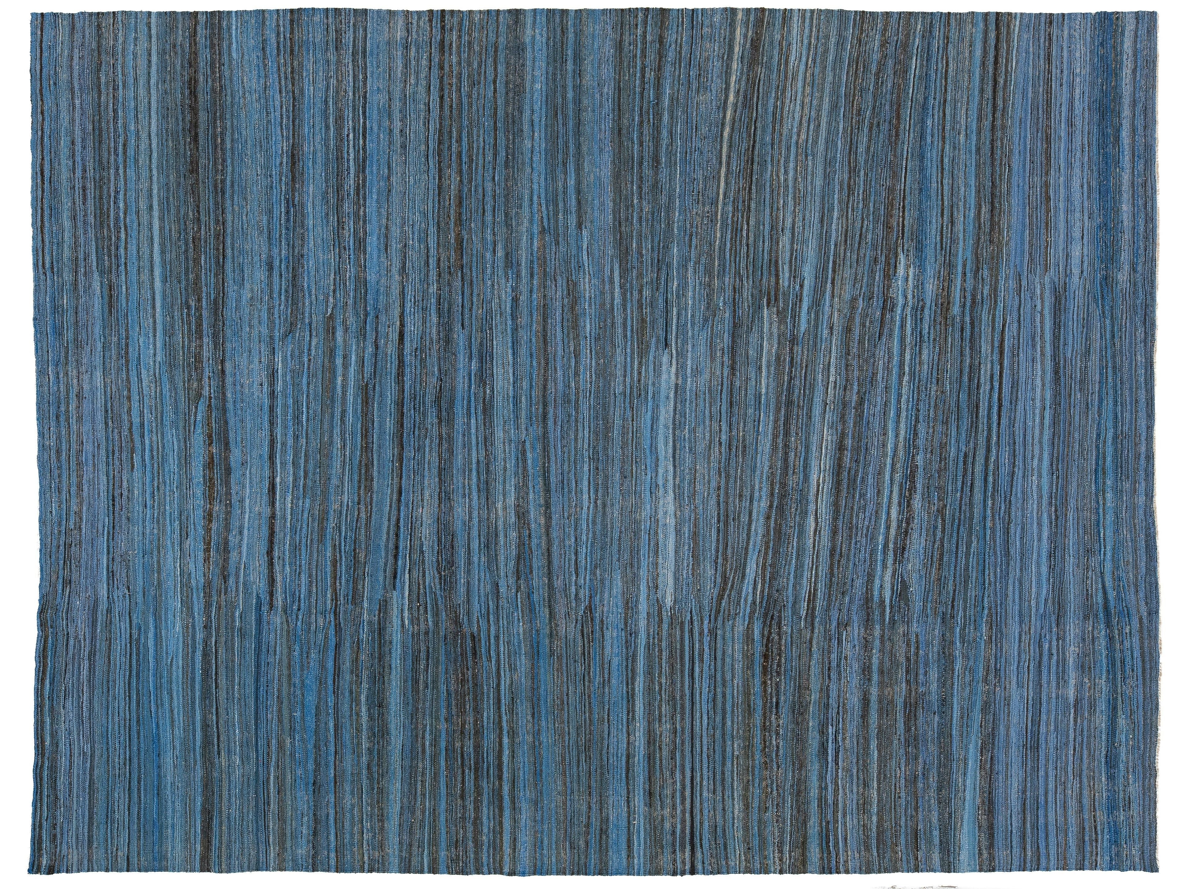A square area rug with a textured horizontal stripe pattern in shades of blue, navy, and gray.
