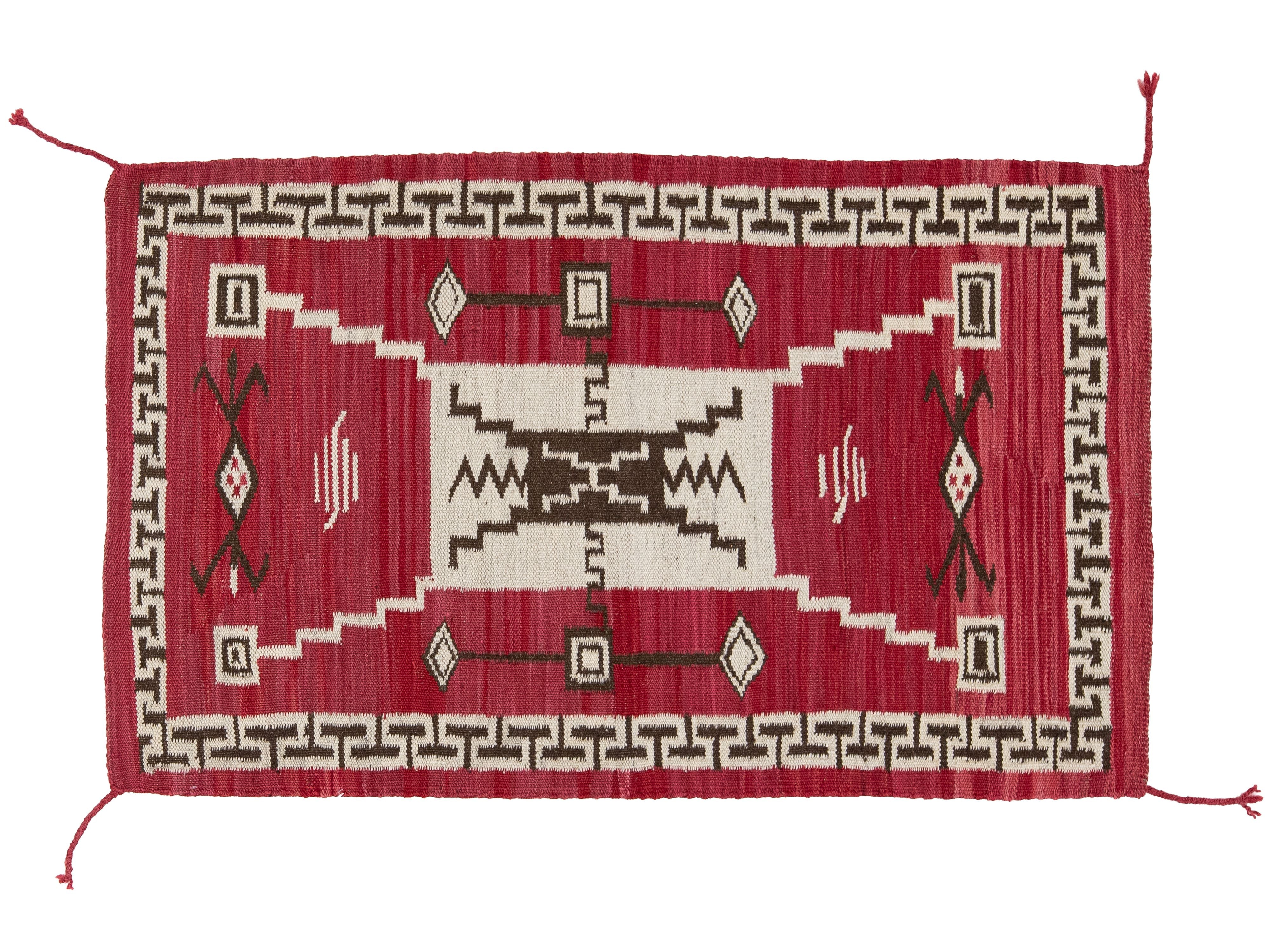 A rectangular woven rug with a red field, cream central panel, dark brown geometric motifs, and a repeating border pattern, shown flat against a white background.