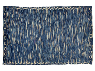 A rectangular area rug with a textured, hand-woven appearance. The design features a dominant medium blue field with vertical wavy lines in cream and beige, framed by a decorative border with small blue and beige dots.