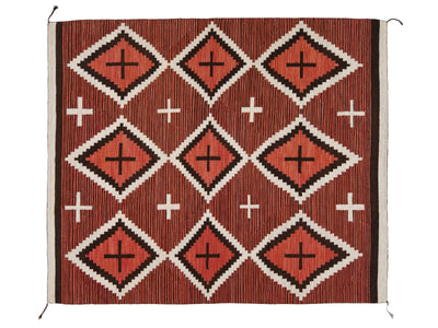 A rectangular woven textile rug or blanket with a geometric Southwestern-style pattern, featuring terracotta red, black, and off-white diamond motifs with cross accents and vertical striped texture.