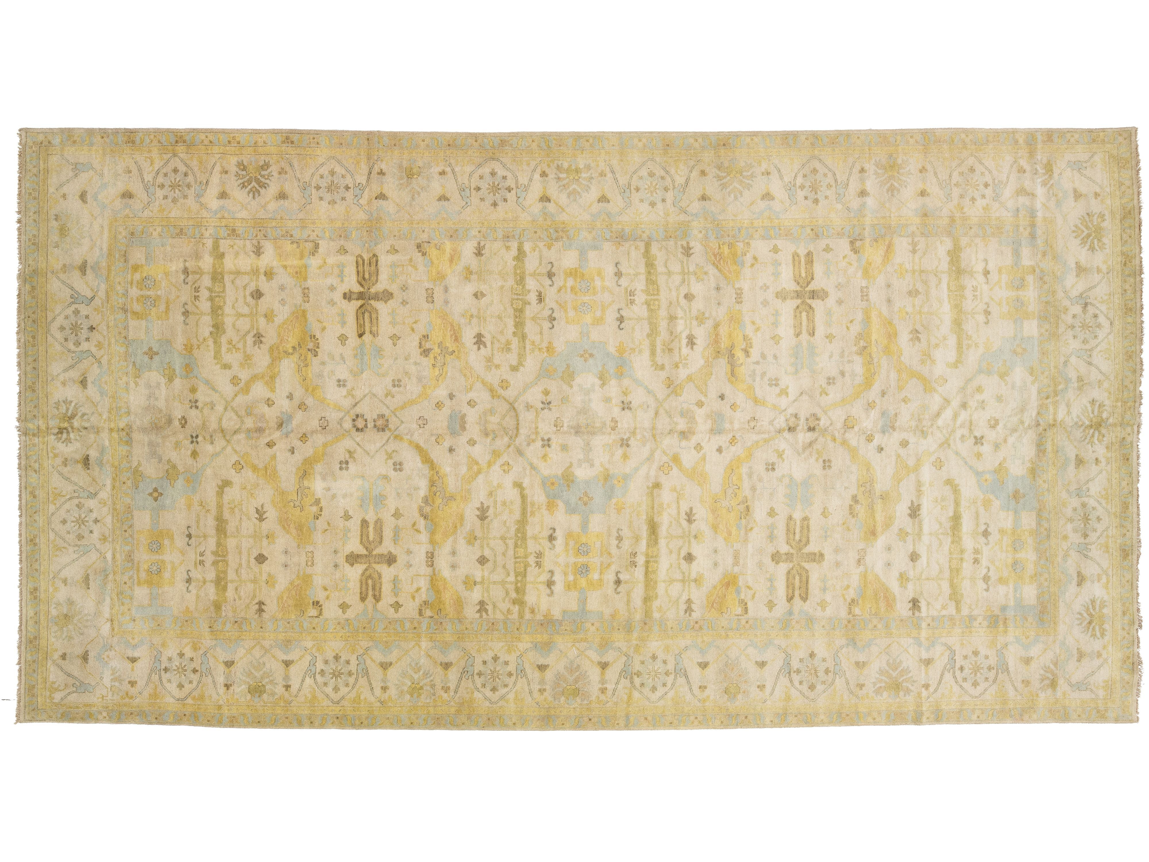 A rectangular oushak-style area rug with an intricate traditional pattern in pale yellow, beige, and light blue, shown flat against a white background.