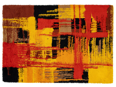 Abstract area rug with a high-pile shag texture, featuring a bold geometric pattern in yellow, red, black, brown, and beige.