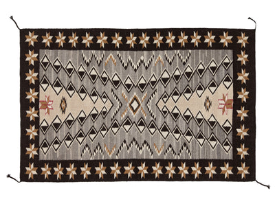 A rectangular woven rug with a Southwestern geometric pattern, featuring a dark brown border, a central gray diamond motif, and beige star details on a white background.