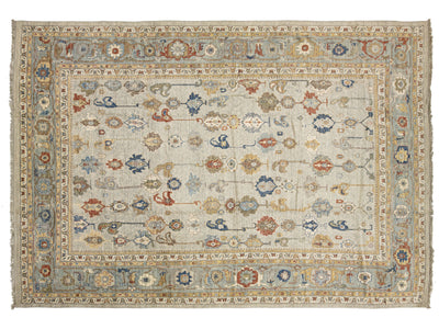An oushak-style oriental rug with a distressed cream background, featuring intricate floral and medallion motifs in muted blue, rust red, and beige tones, complete with a detailed border and fringe.