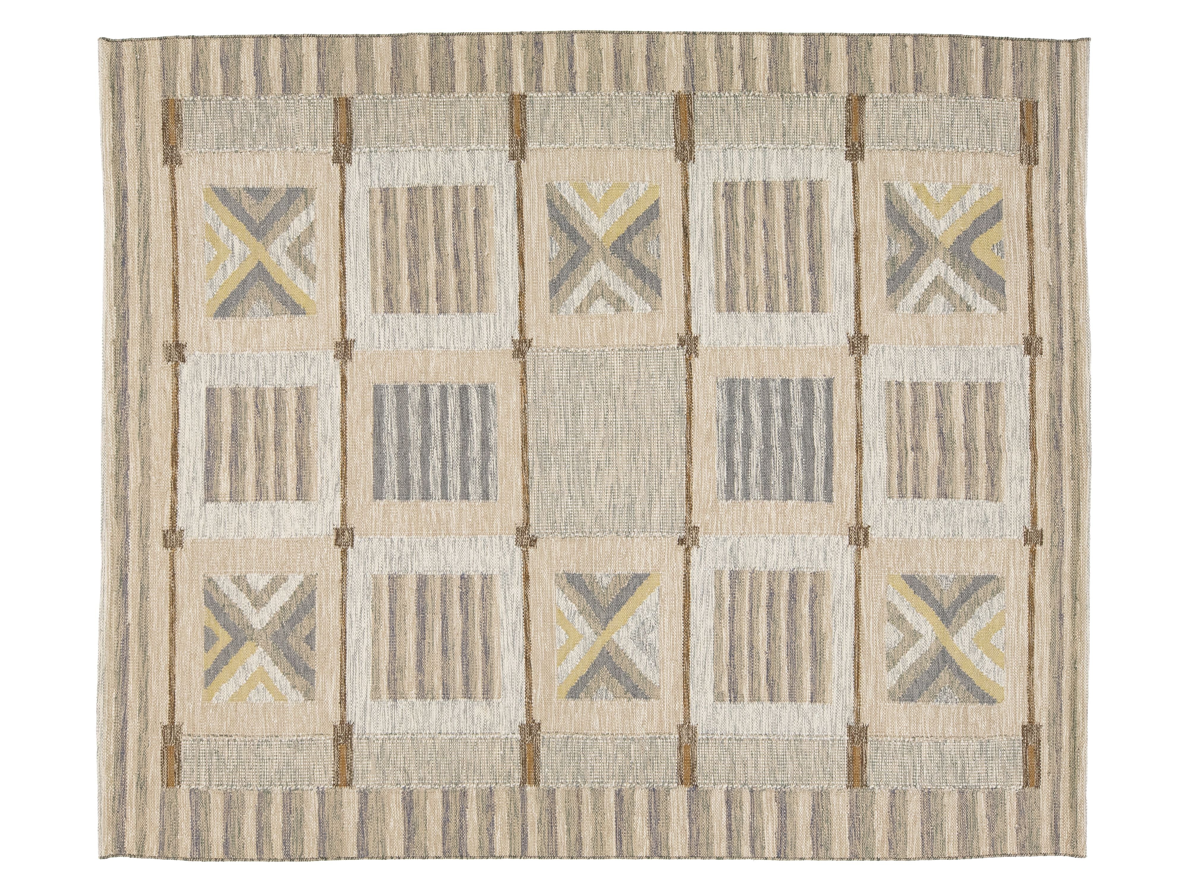 A rectangular woven area rug with a geometric patchwork design in beige, gray, and muted yellow, featuring a striped border and central block pattern.
