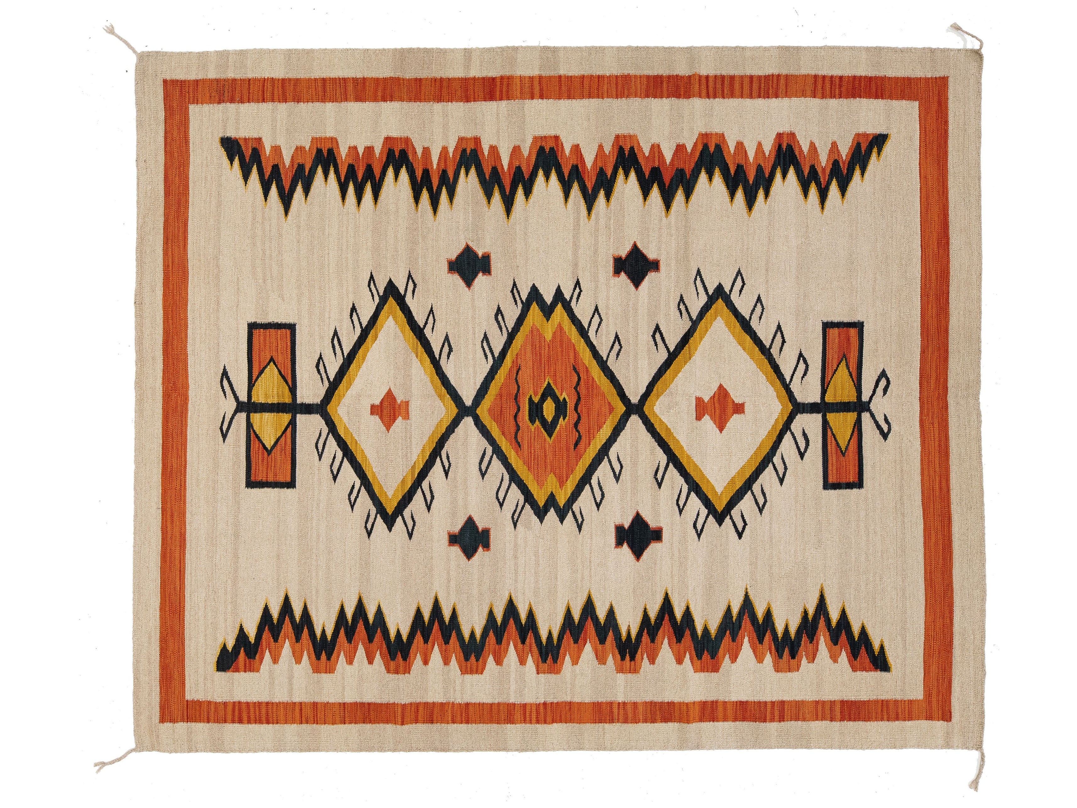 A rectangular woven rug with a Southwestern geometric pattern, featuring orange, black, yellow, and cream colors on a natural beige background.