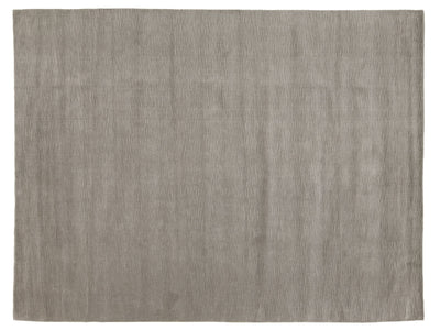 A rectangular area rug with a textured, woven surface in a warm taupe-gray color.