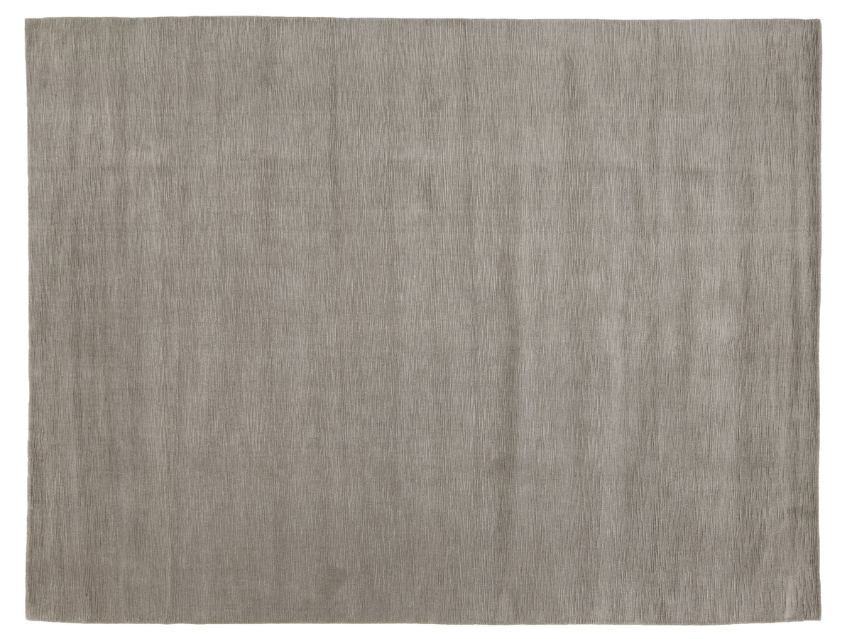 A rectangular area rug with a textured, woven surface in a warm taupe-gray color.