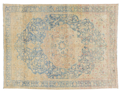 A distressed traditional area rug with a faded central medallion, featuring a warm beige base color with faded blue, dusty pink, and light orange floral patterns.