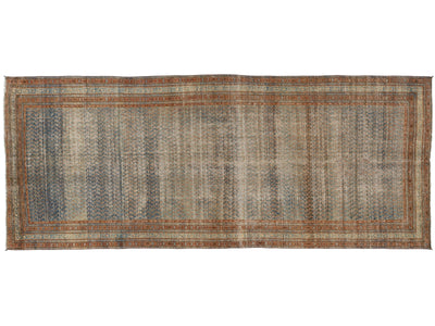 A rectangular vintage-style area rug with an intricate, distressed pattern in muted tones of blue, beige, brown, and rust orange.