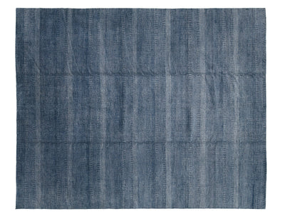 A rectangular modern savannah indigo blue rug with a textured, horizontally ribbed pattern.