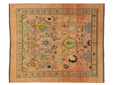 A square vintage-style wool rug with a warm terracotta and peach field, featuring a central floral medallion, scrolling vine motifs, and a detailed geometric border.