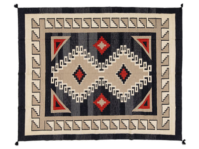 A rectangular woven rug with a Southwestern geometric pattern, featuring a black outer border, cream and beige borders, and red and black central diamond motifs.
