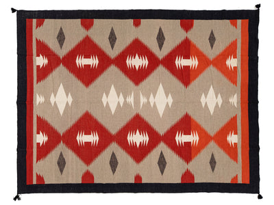 A rectangular woven rug with a Southwestern geometric pattern, featuring red and orange diamonds, white and gray accents, and a black border.