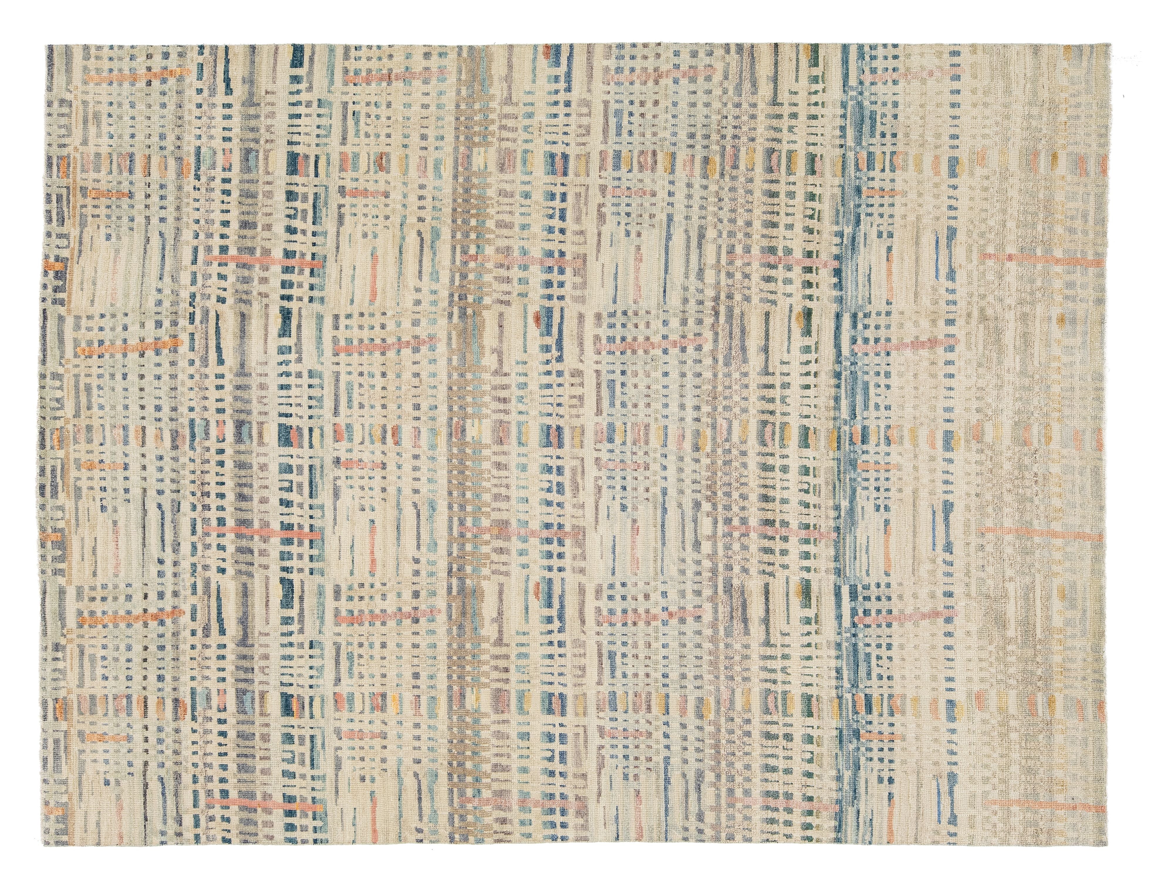 A rectangular area rug with an abstract, textured basketweave pattern in cream, beige, light blue, and muted orange.