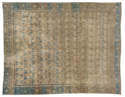 An antique oriental rug with a distressed pattern, featuring a central field of beige and brown medallions, a blue border, and faded details throughout.