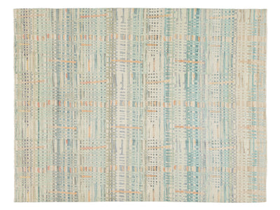 A rectangular area rug with an abstract vertical striped pattern in muted teal, beige, cream, and light orange.