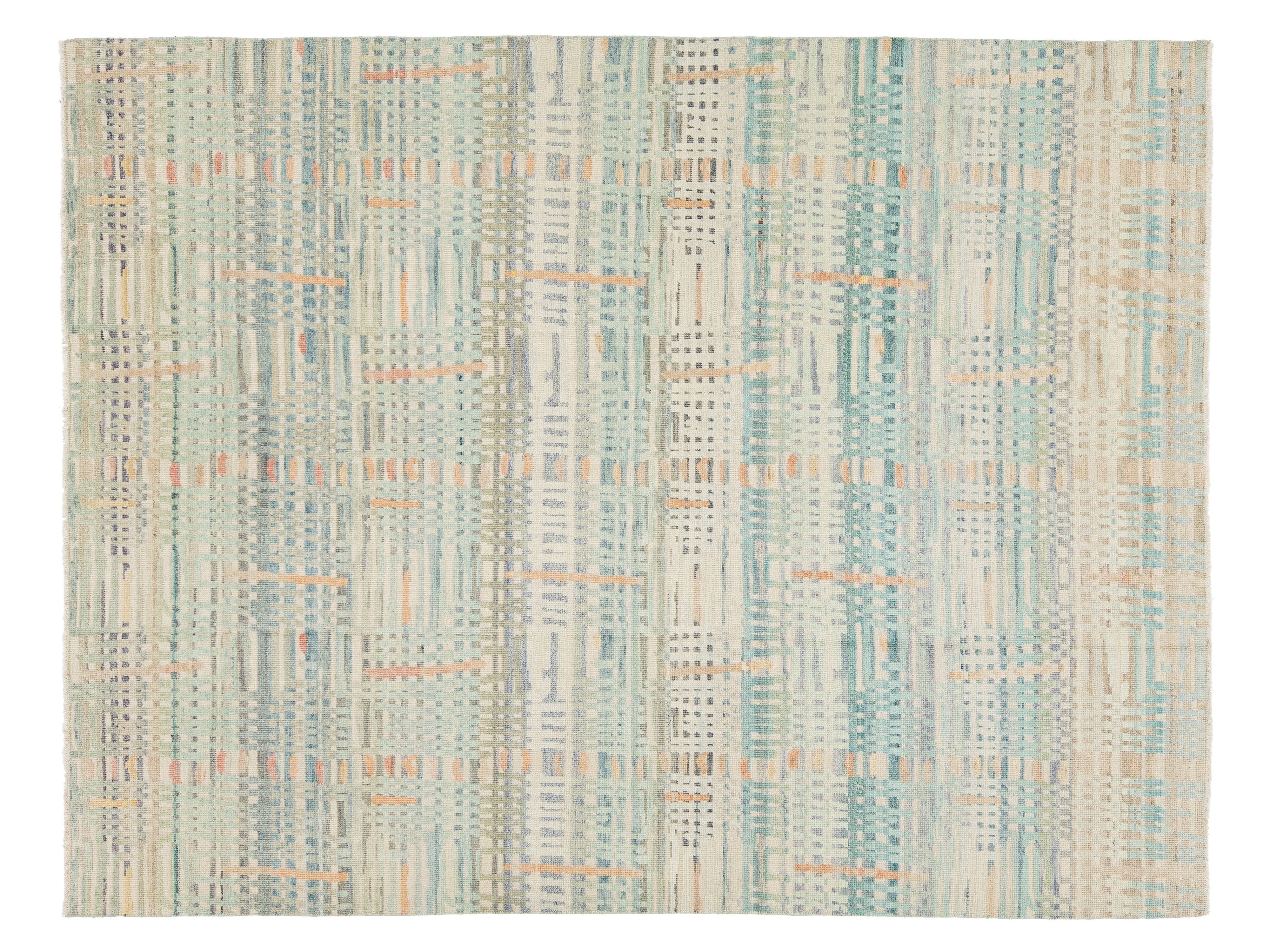 A rectangular area rug with an abstract vertical striped pattern in muted teal, beige, cream, and light orange.