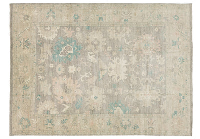A rectangular area rug, traditional pattern in muted beige, gray, and soft teal blue.