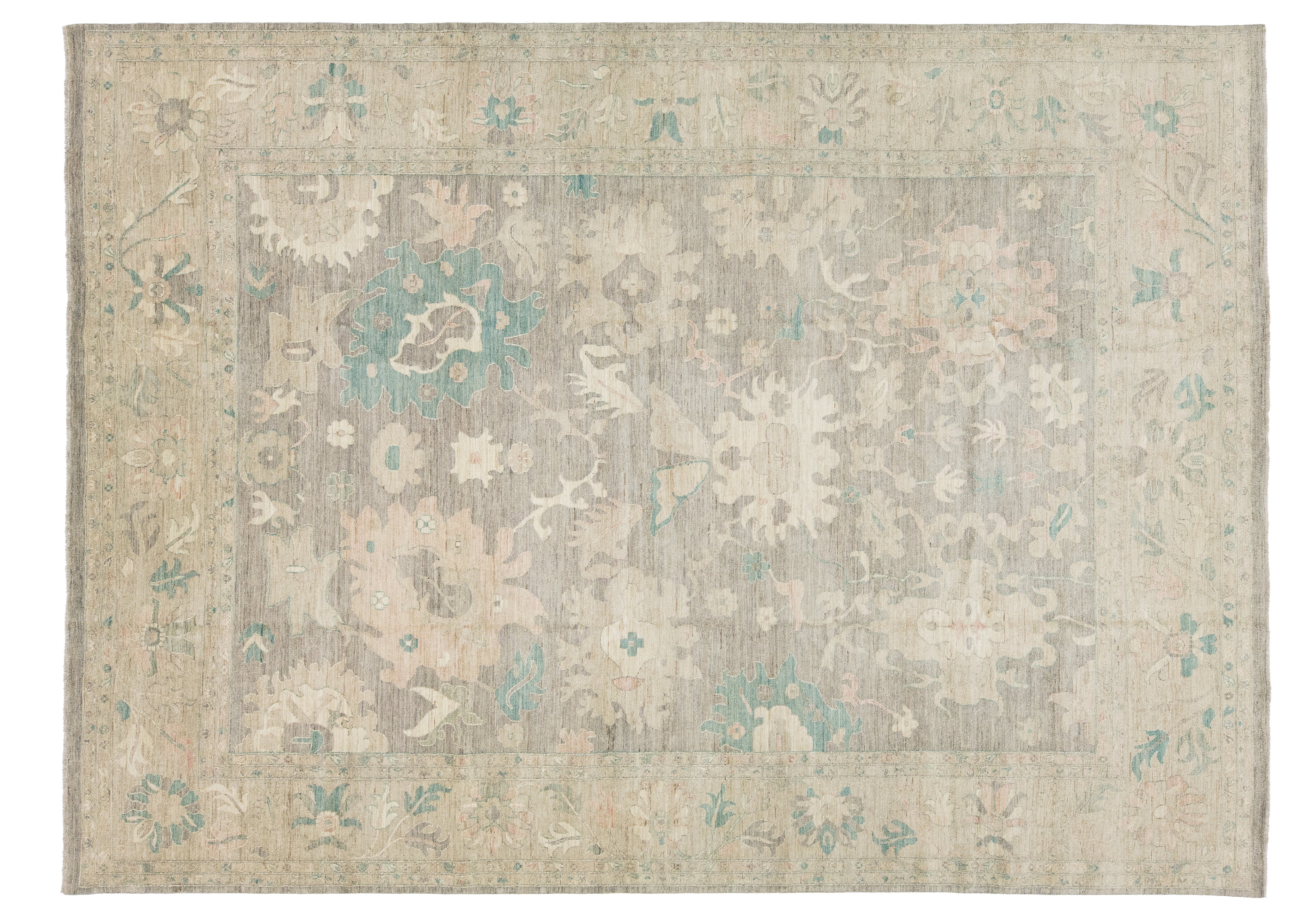 A rectangular area rug, traditional pattern in muted beige, gray, and soft teal blue.