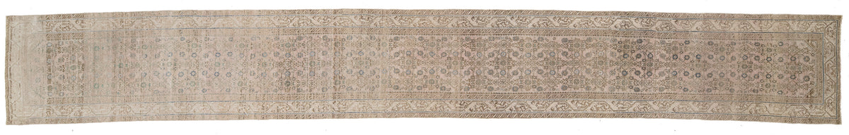 A runner rug with an intricate traditional pattern in muted beige, gray, and brown tones, shown flat against a white background.