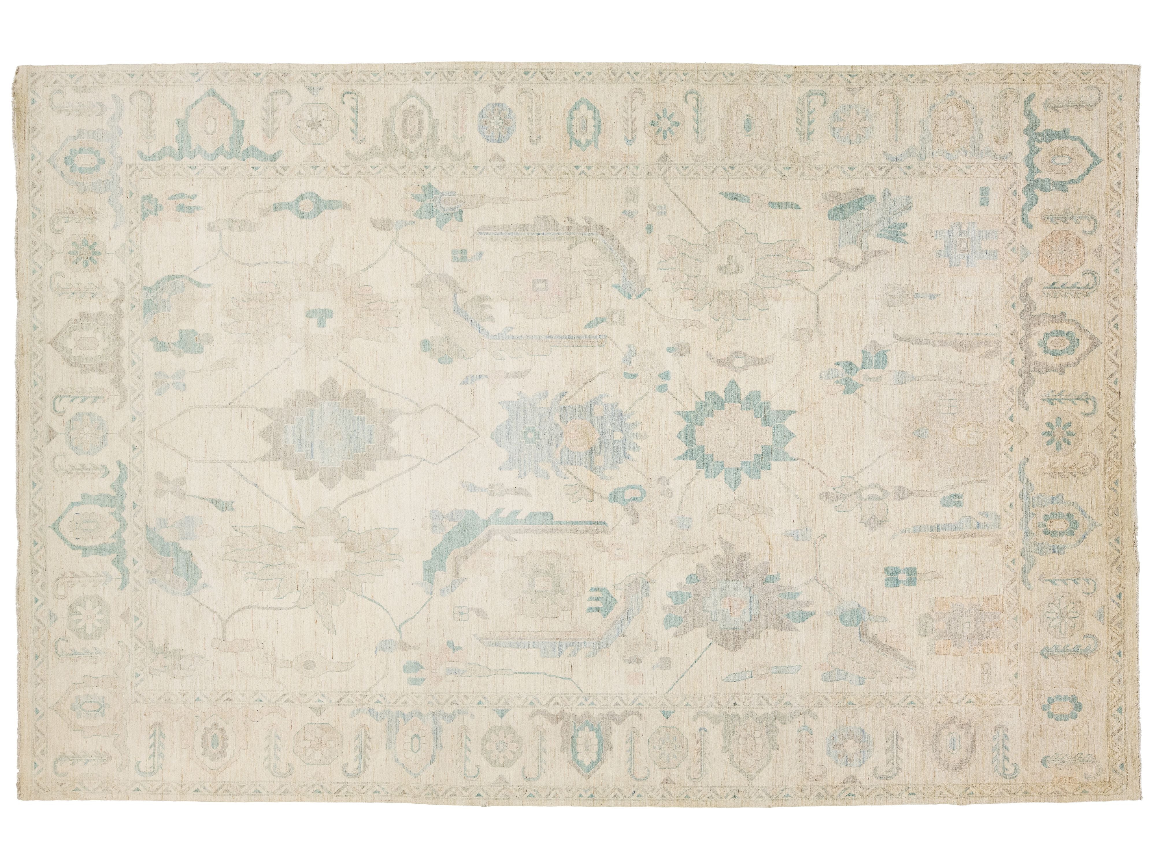 A rectangular area rug with a traditional pattern in cream, beige, light blue, and muted gray tones.