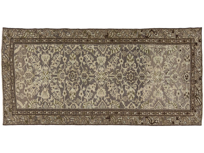 A rectangular vintage area rug with an ornate floral and medallion pattern, featuring a muted gray-blue center field, beige and cream motifs, and a detailed brown border.