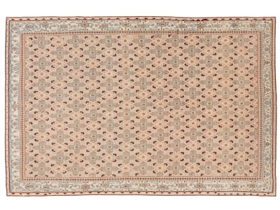 A rectangular area rug with an intricate geometric and floral pattern in beige, brown, muted blue, and terracotta red, shown flat against a white background.