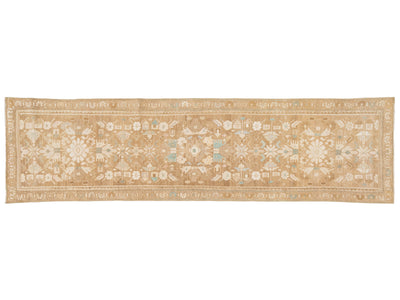 A runner rug with an intricate traditional pattern in beige, cream, and light blue, shown flat against a white background.