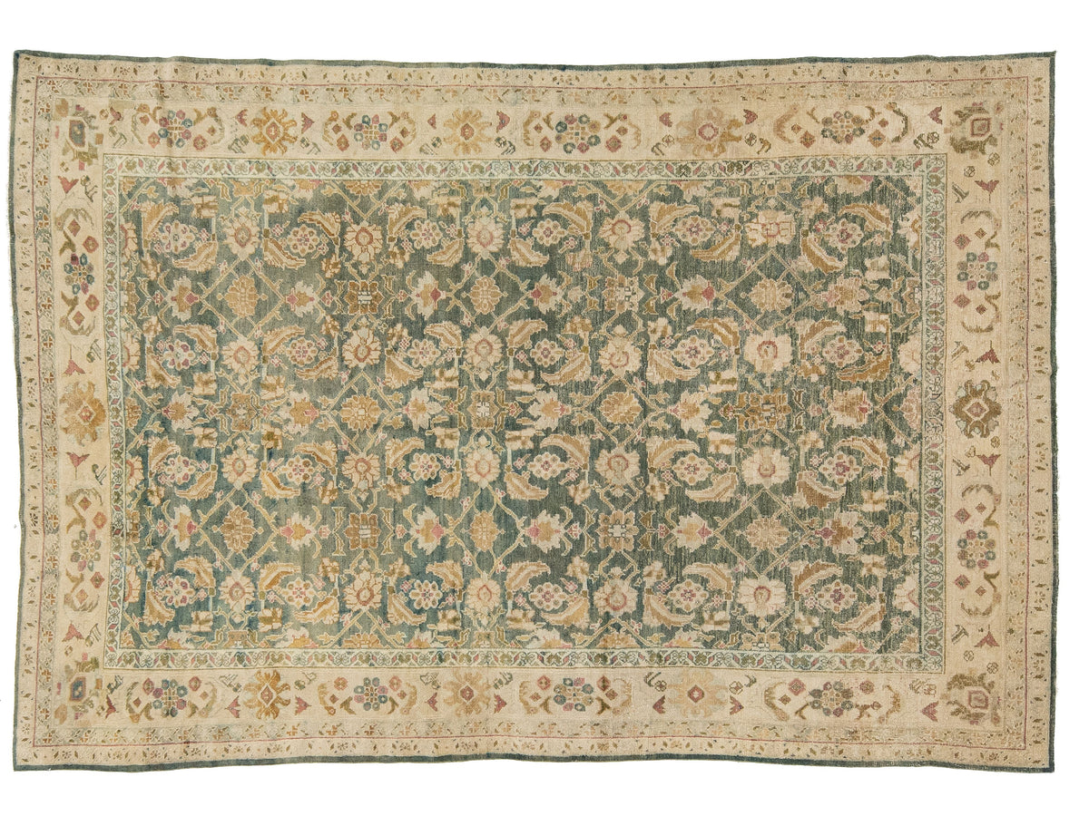 An antique oriental Agra rug with a teal-green center field, beige borders, and cream floral motifs.