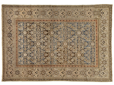 An antique oriental Malayer rug with a detailed floral pattern, featuring a dusty blue center field surrounded by beige, brown, and rust borders.
