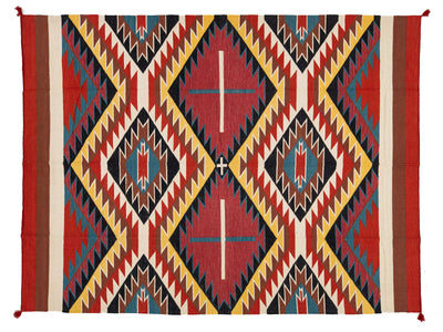 A Southwestern-style woven rug with a bold geometric pattern in red, yellow, black, blue, and beige, featuring diamond and zigzag motifs.