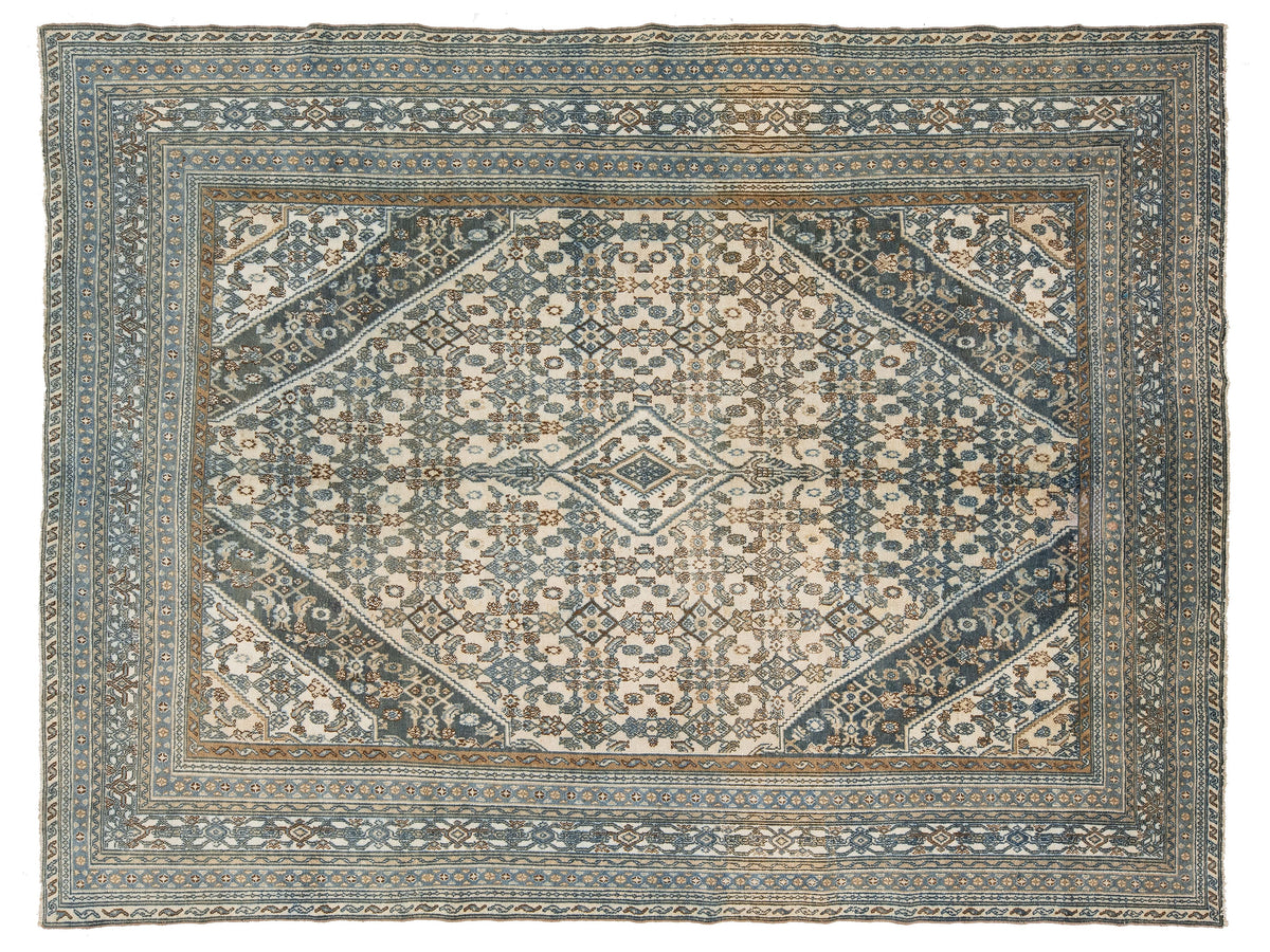 An vintage oriental rug with a distressed pattern in muted blue, beige, and brown tones, featuring a central medallion and detailed borders.