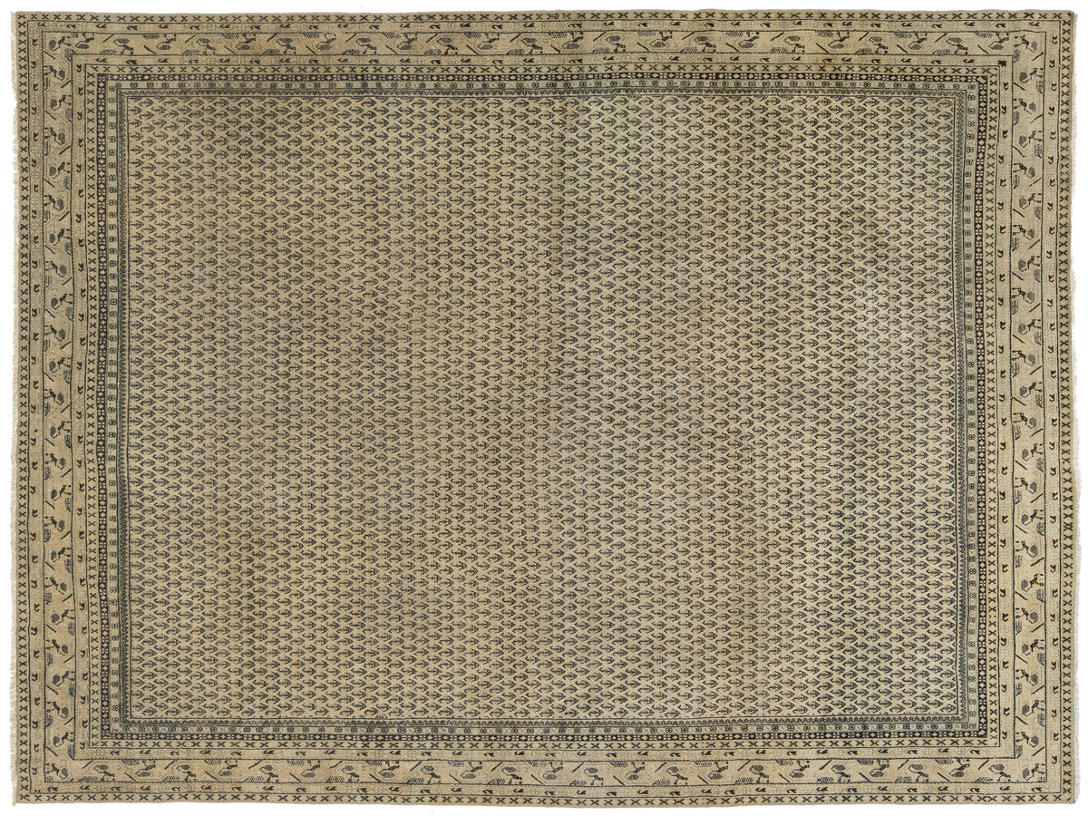 A rectangular area rug with a traditional geometric pattern in beige, gray, and muted blue-gray tones, featuring a dense central field and a detailed border.