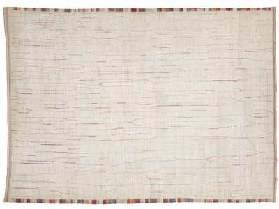 A square off-white woven rug with a textured, handwoven appearance, featuring subtle multicolor linear patterns in red, blue, and orange across the surface, finished with a striped multicolor border along the edges.