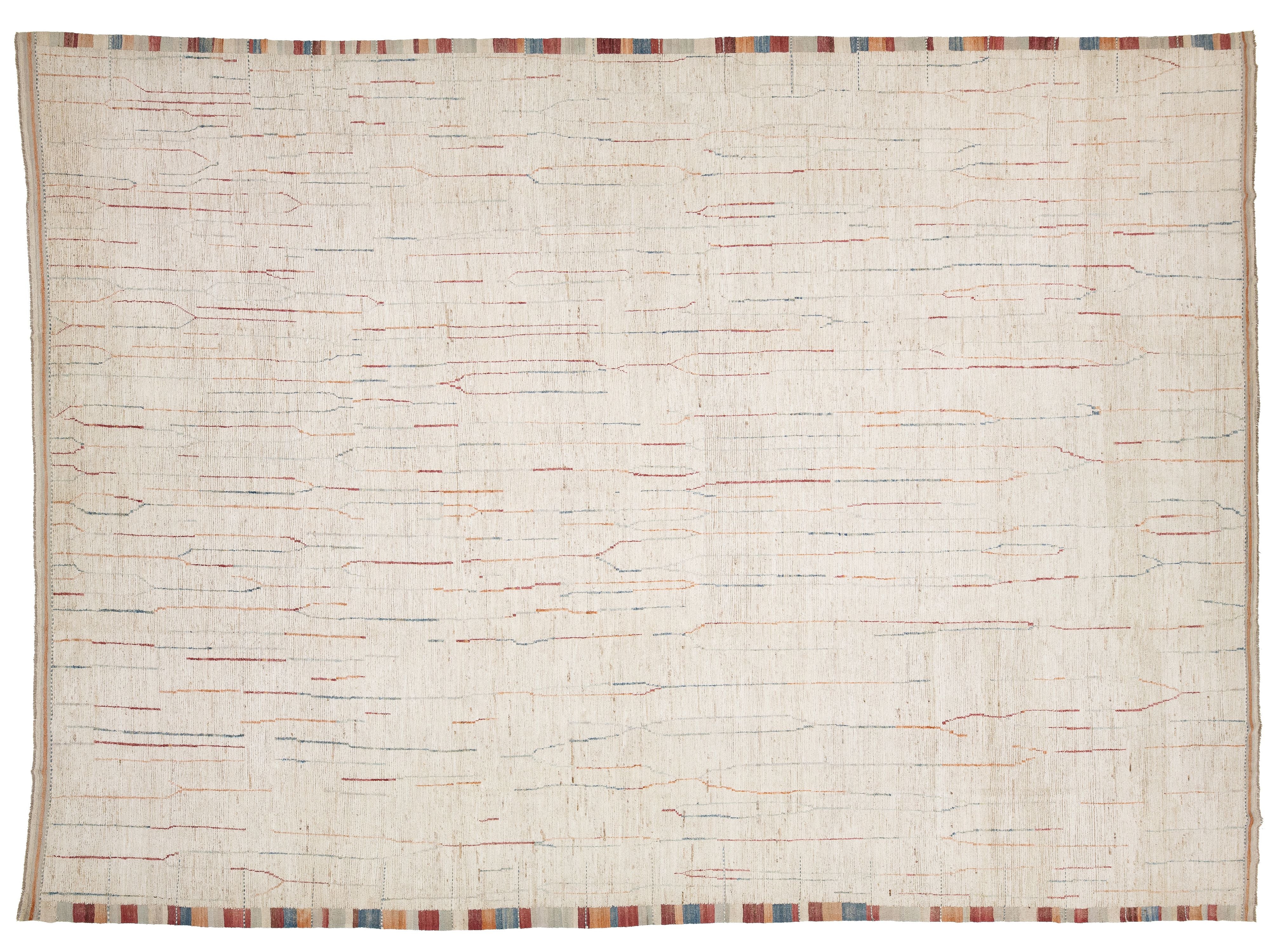 A square off-white woven rug with a textured, handwoven appearance, featuring subtle multicolor linear patterns in red, blue, and orange across the surface, finished with a striped multicolor border along the edges.