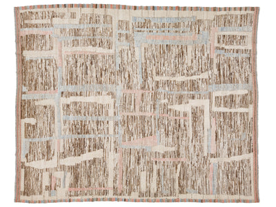 A square abstract patterned rug with a textured, woven appearance. The design features a grid-like layout with vertical brushstroke patterns in brown, beige, and cream, accented by light blue and pale pink lines.