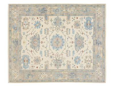 A traditional oriental-style area rug with an intricate floral and geometric medallion pattern, featuring a cream center, a light blue border, and accents of beige, gray, and rust red.