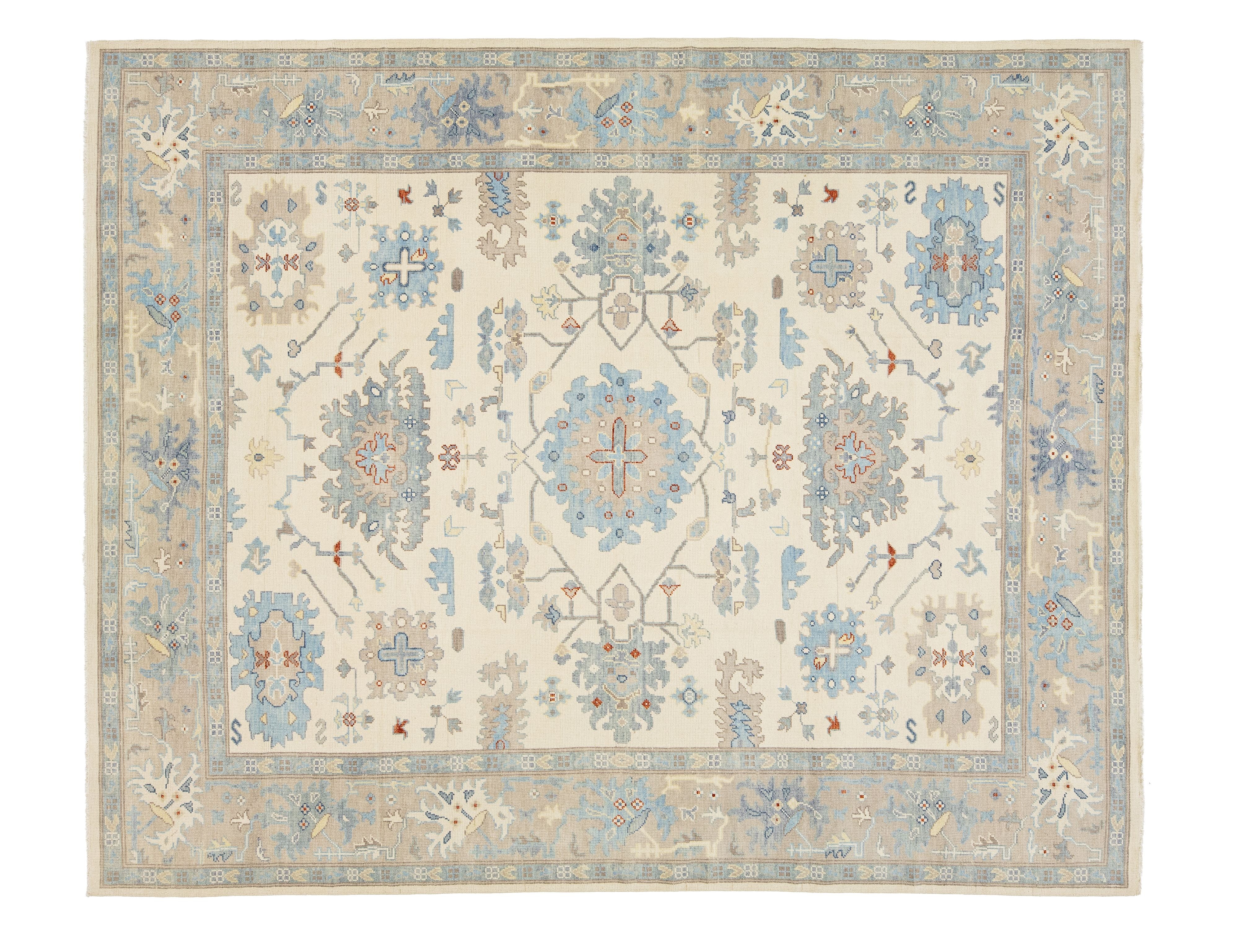 A traditional oriental-style area rug with an intricate floral and geometric medallion pattern, featuring a cream center, a light blue border, and accents of beige, gray, and rust red.