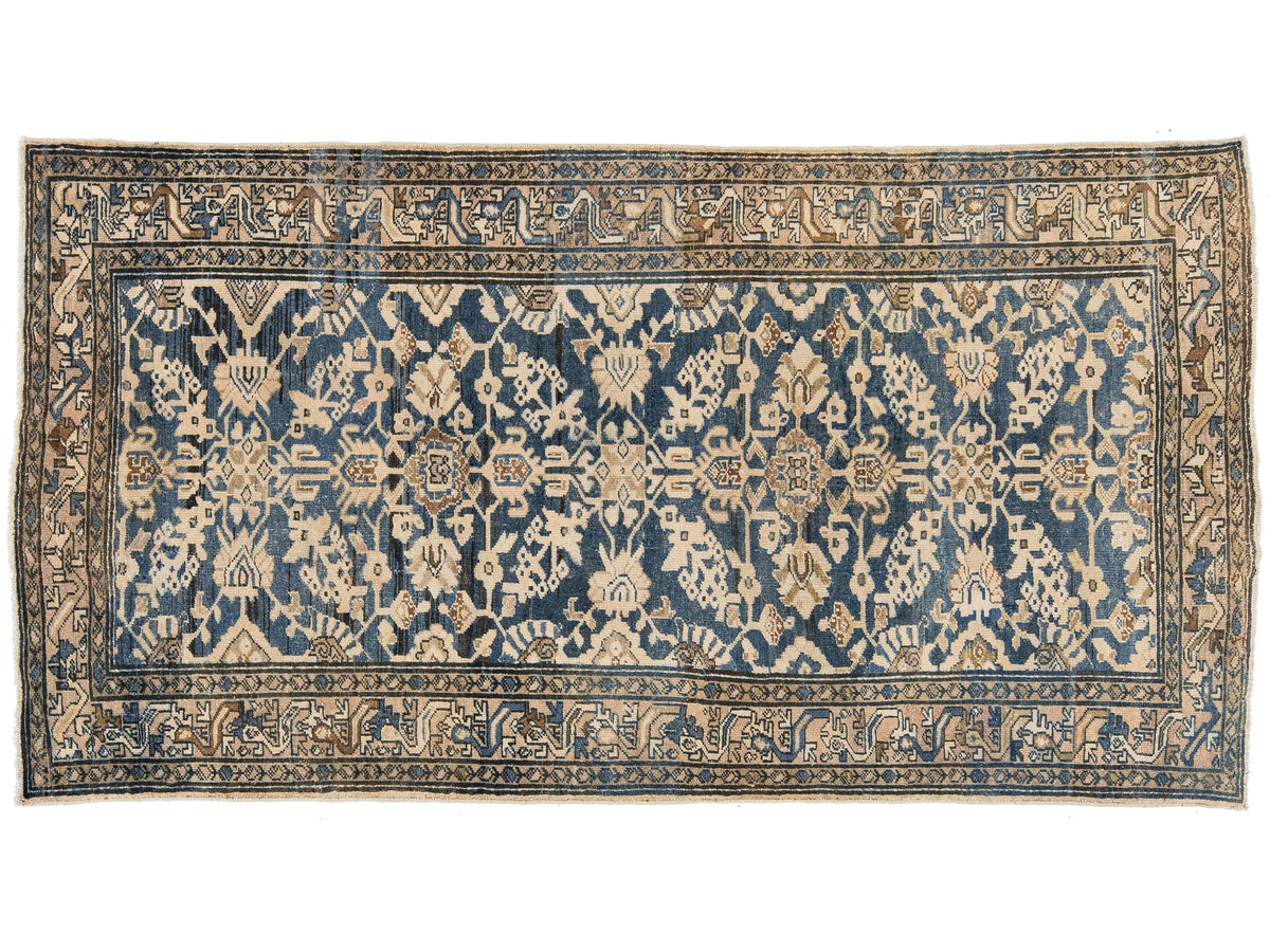 A vintage oriental rug with a navy blue field, beige and cream floral motifs, and a detailed patterned border.