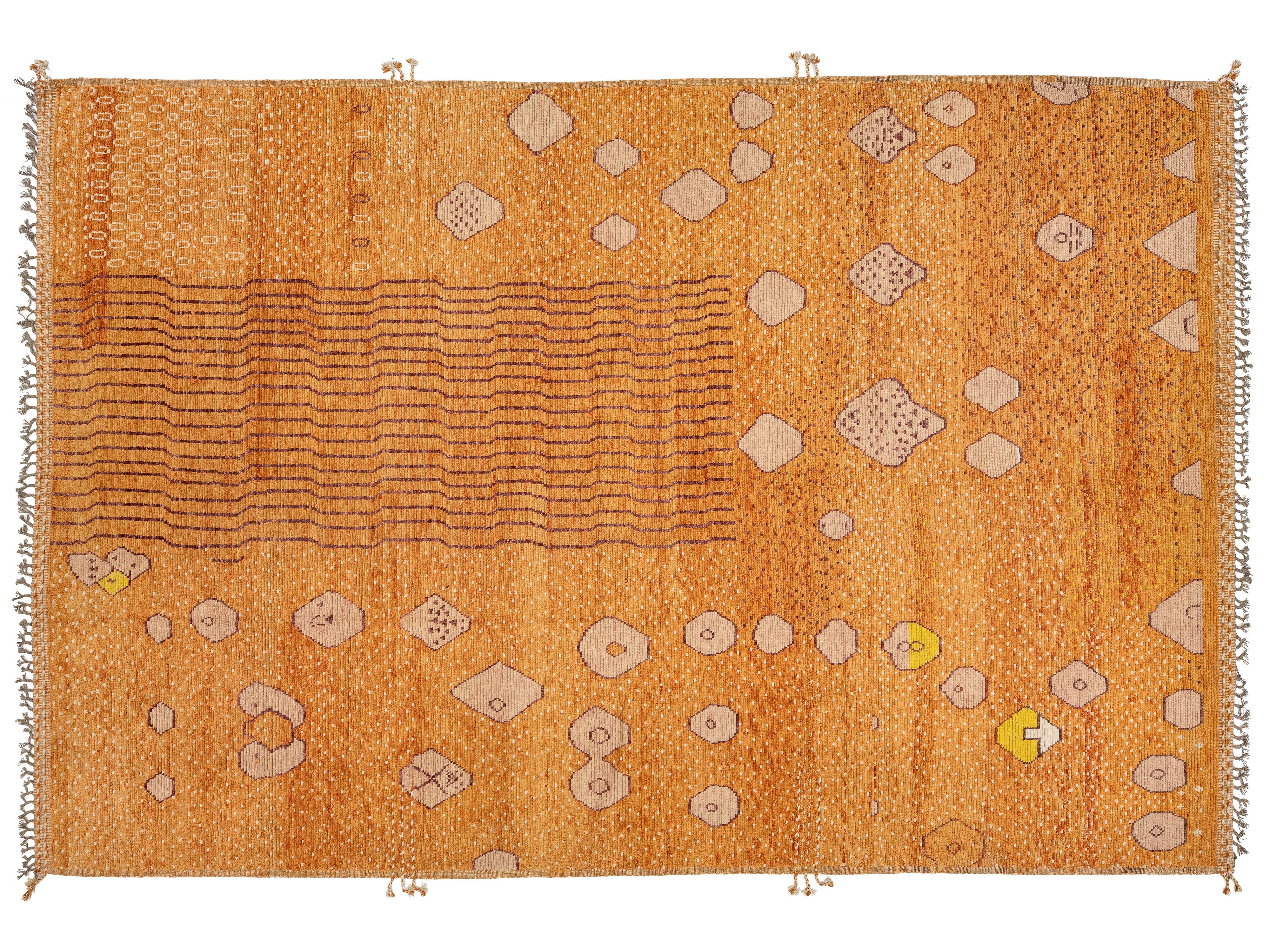 A rectangular orange-brown woven rug with beige geometric motifs, horizontal wavy lines, and small yellow accents, shown flat against a white background.