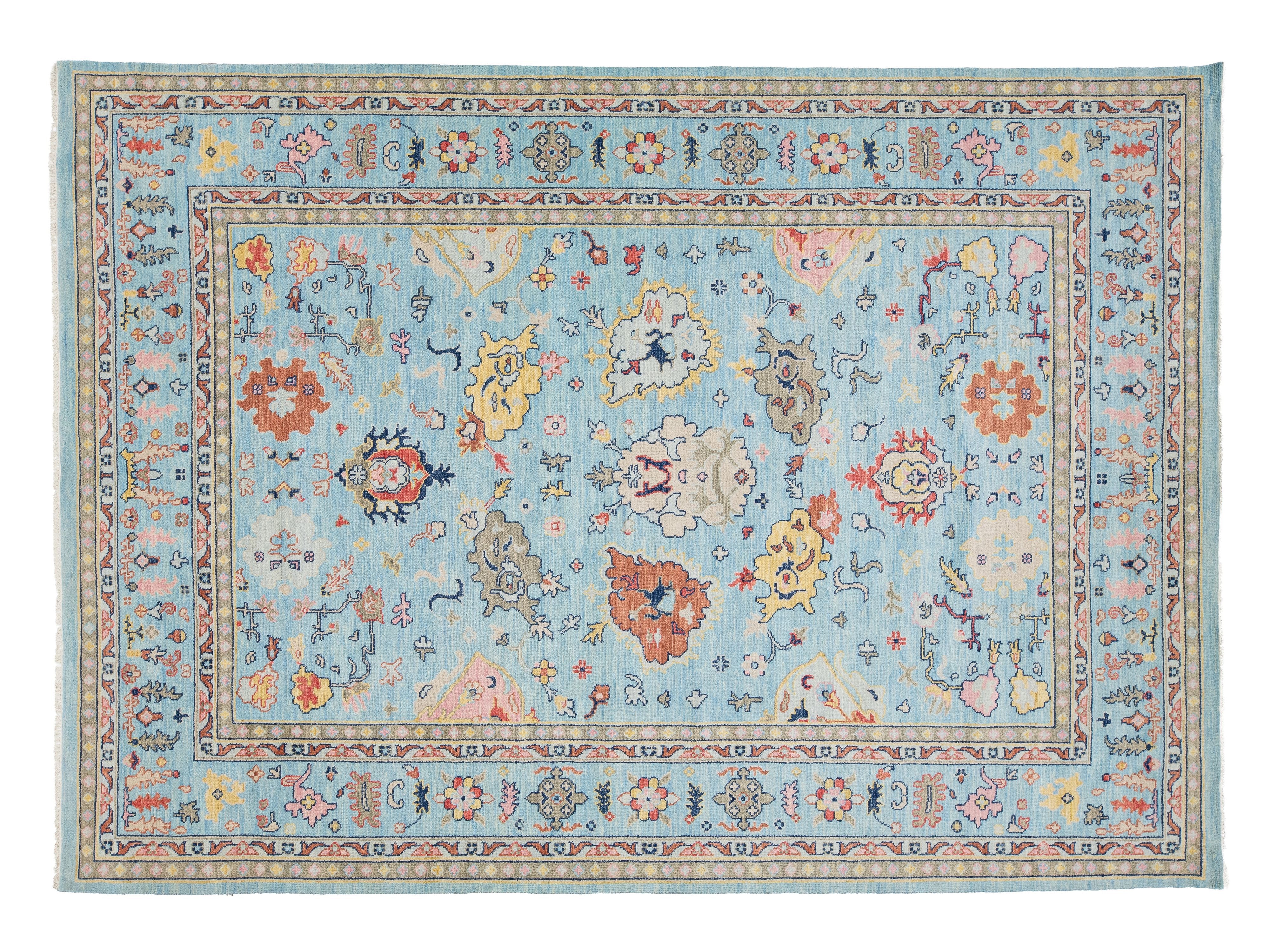 A rectangular area rug with a traditional Persian-style floral pattern on a light blue background, featuring a multi-colored border and central medallion design.