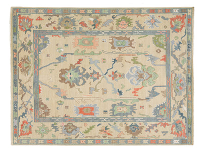 A rectangular oushak-style area rug with a cream-colored field and a detailed multicolor floral and geometric border pattern.