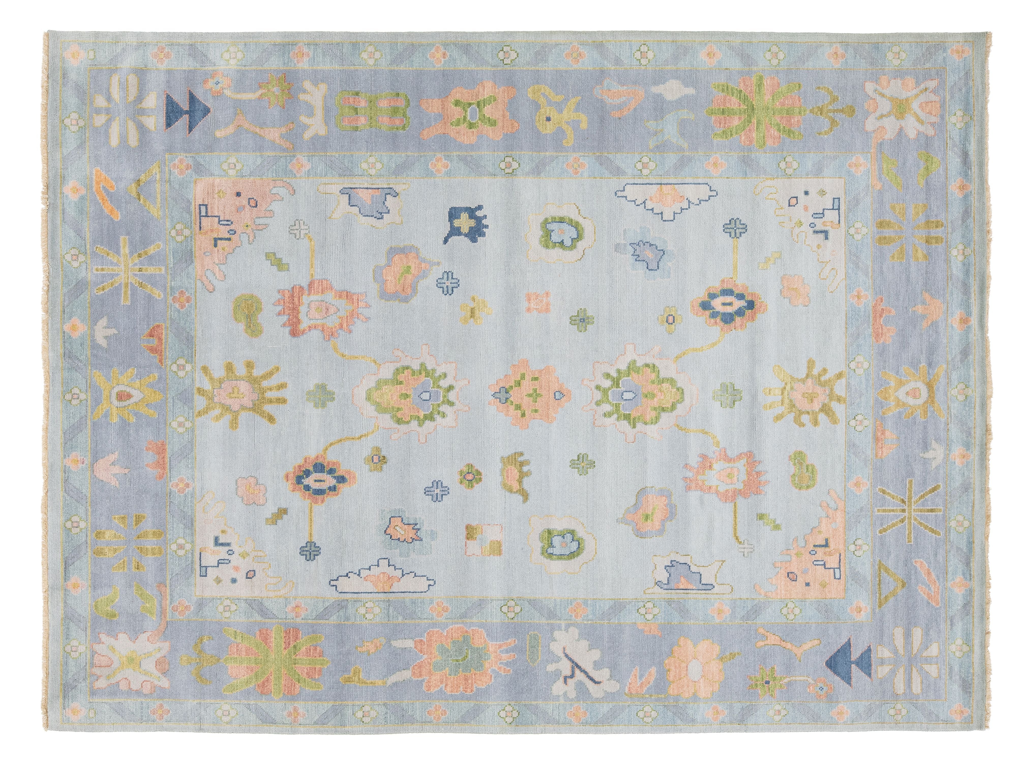 A rectangular area rug with a light blue-gray field and border, decorated with intricate floral and geometric motifs in pastel pink, sage green, soft yellow, and touches of blue.