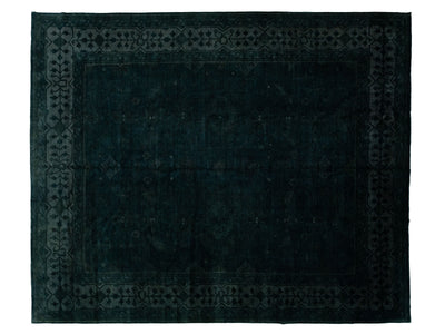 A dark green-navy blue rectangular area rug with a distressed, contemporary-style pattern and a decorative border, shown flat against a white background.